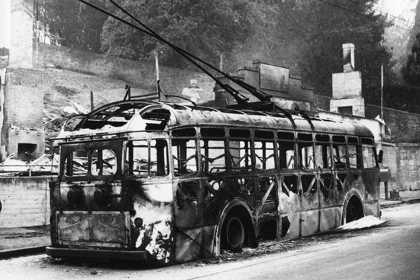 Black and white photo of a burnt up bus tram during the '67 bushfires in Tasmania