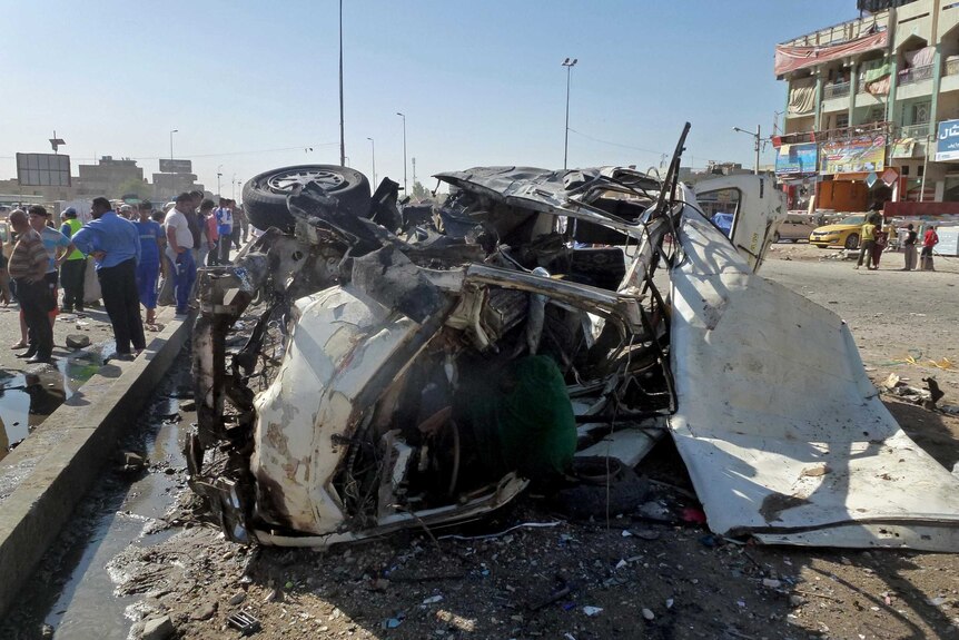 Iraqis inspect the site of a car bomb explosion in Sadr City.