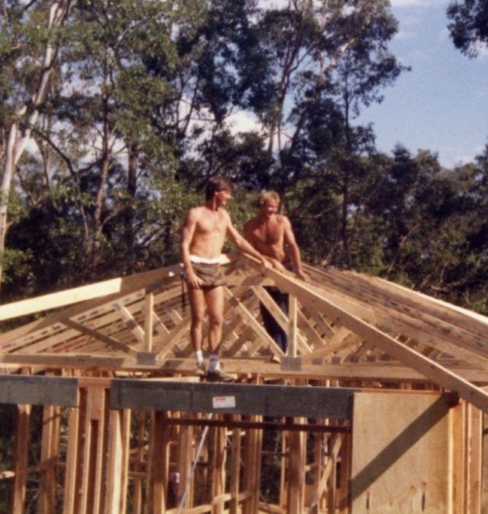 Un joven Barry Du Bois sin camisa se encuentra en lo alto de una casa en construcción.
