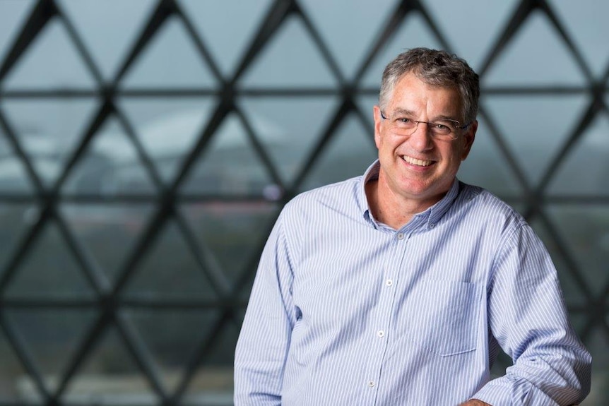 Professor Steve Wesselingh is executive director of SAHMRI. He stands in front of a window with triangle panels.