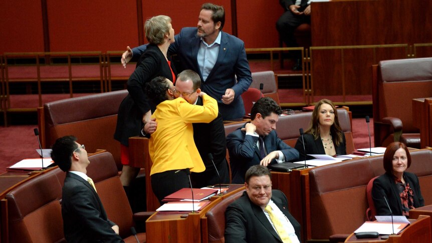 Jacqui Lambie and Ricky Muir (centre) hug during the swearing in of new senators.