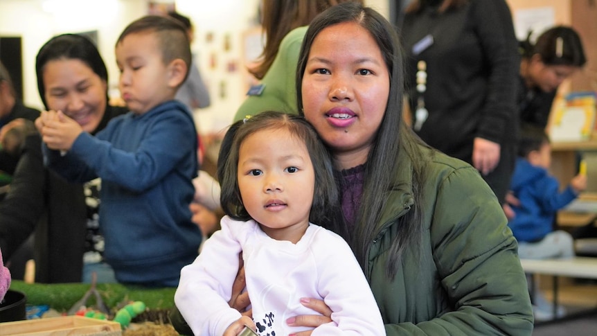 A woman and her young daughter pose for a photo