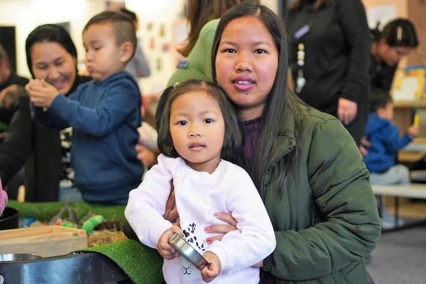 A woman and her young daughter pose for a photo