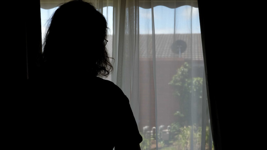 A silhouette image of a woman staring out a window in south west Victoria.