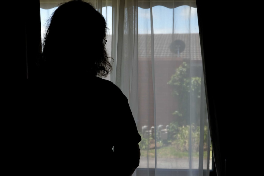 A silhouette image of a woman staring out a window in south west Victoria.