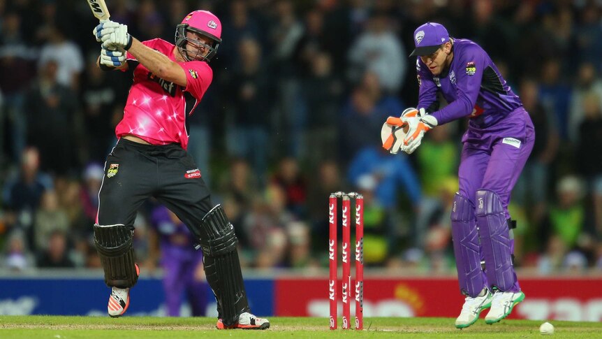 Michael Lumb of the Sixers bats as wicketkeeper Tim Paine of the Hurricanes looks on during the Big Bash League match between the Hobart Hurricanes and the Sydney Sixers