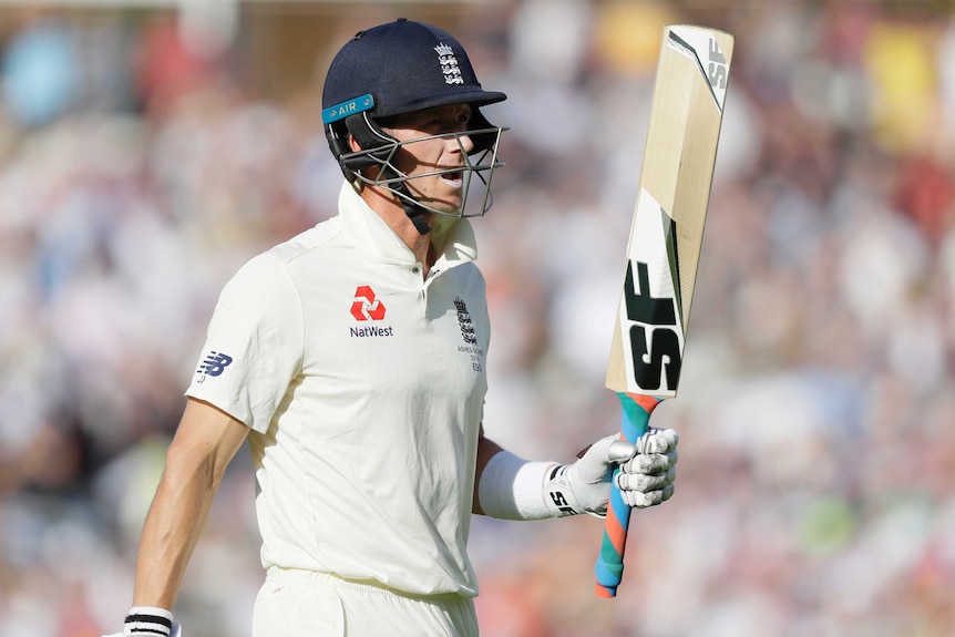 England batsman Joe Denly looks disappointed as he holds the bat up while leaving the field in a Test.