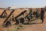 Syrian forces inspect weapons left behind by Islamic State.