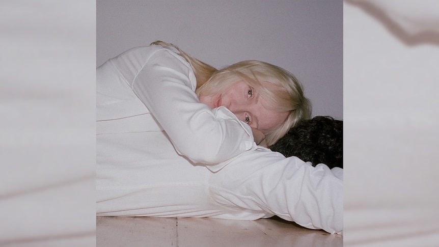 Laura Marling lies on the floor wearing a white shirt on the cover of Song For Our Daughter