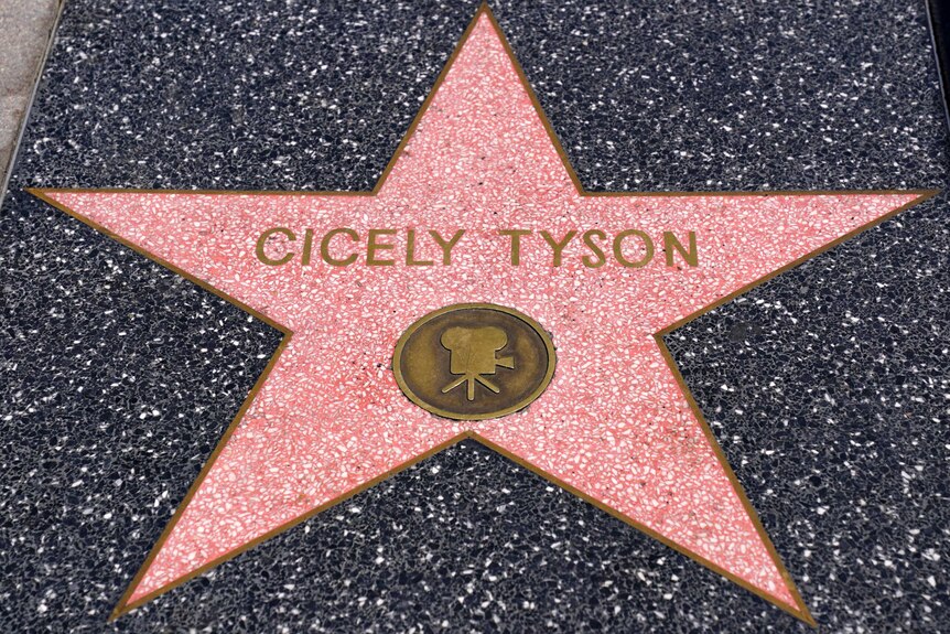 A pink star on the Hollywood Walk of fame sits among wider dark stone. It's for Cicely Tyson and a camera is underneath her name