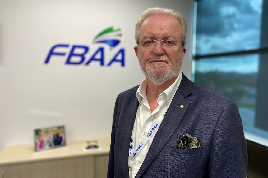 Peter White stands in front of FBAA signage.