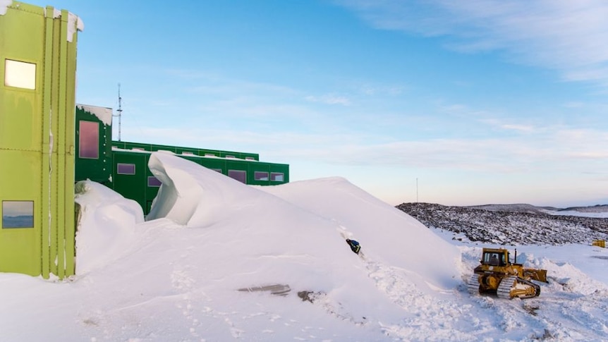 A worker starts to clear a snow drift