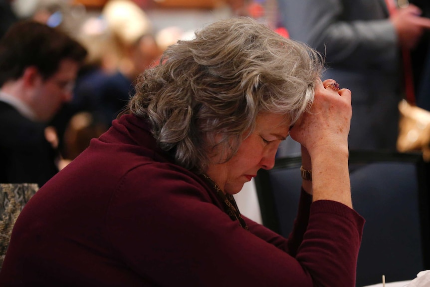 A supporter of Republican Roy Moore prays after media began to call the election for rival, Doug Jones.