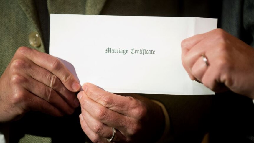 A couple holding a marriage certificate