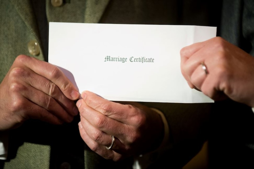 A couple holding a marriage certificate