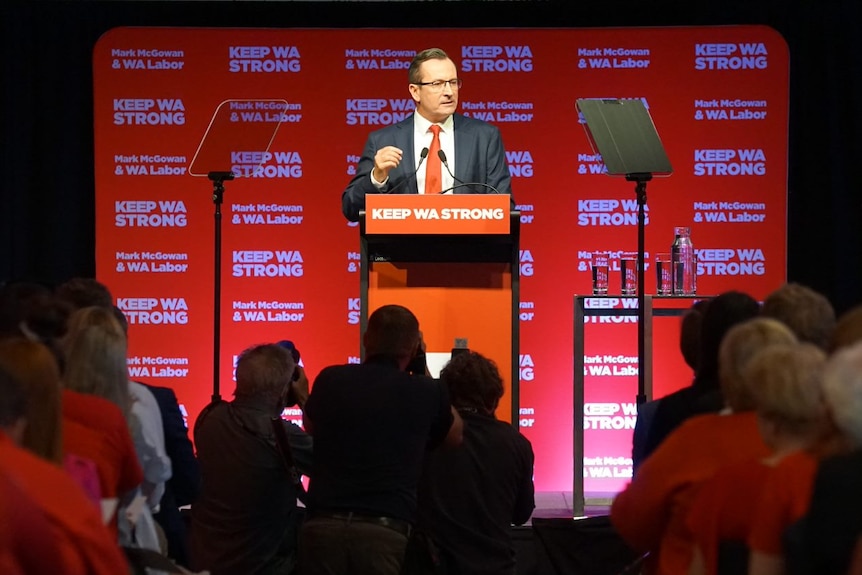 A wide shot of WA Premier Mark McGowan at a podium with the words 'keep WA strong' written on the front.