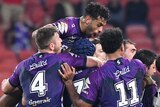 Melbourne Storm NRL players embrace in a group as they celebrate beating Sydney Roosters.