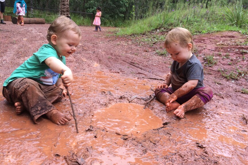 Two children playing in the mud at the Nature School Little Explorers Playgroup in Port Macquarie.
