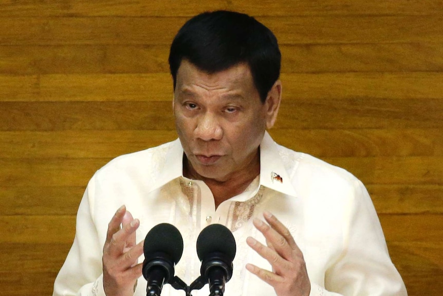 Rodrigo Duterte speaks in front of a lectern