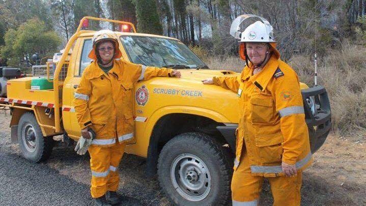 Two women firefighters stand next to a truck at Scrubby Creek