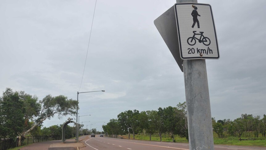 A section of road in Darwin with a few cars rolling along.