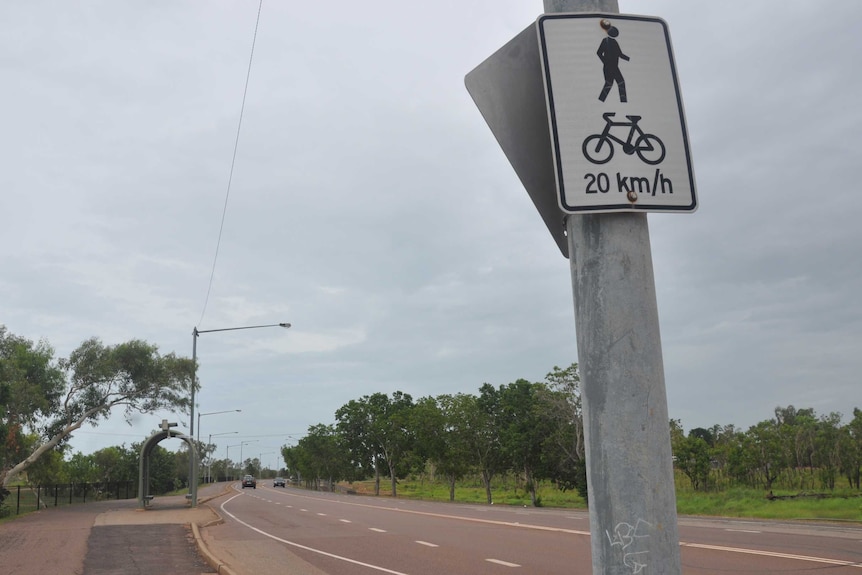 A section of road in Darwin with a few cars rolling along.