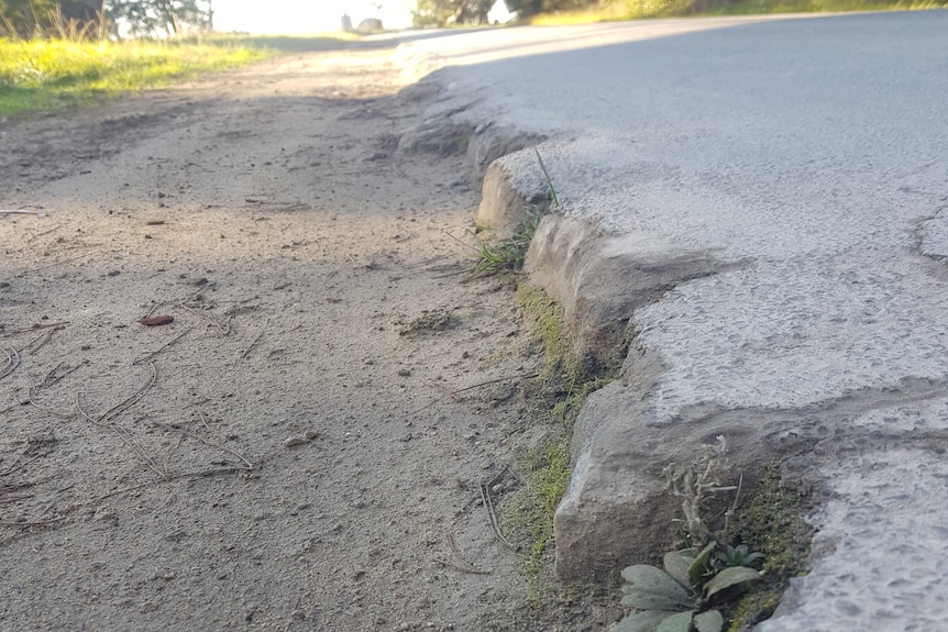 An eroded roadside showing the deterioration of the bitumen edges.