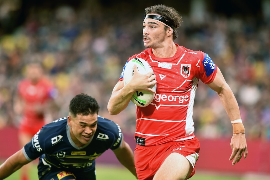 St George Illawarra Dragons' Cody Ramsey runs with the ball away from North Queensland Cowboys' Esan Marsters.