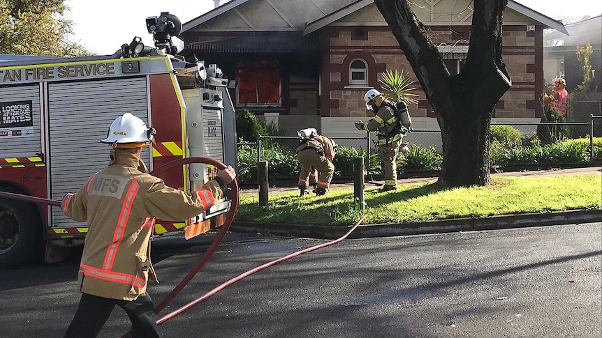 Firefighters attend a burning suburban house.