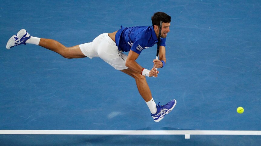 Novak Djokovic stretches to make a backhand on the baseline against Rafael Nadal at the Australian Open final