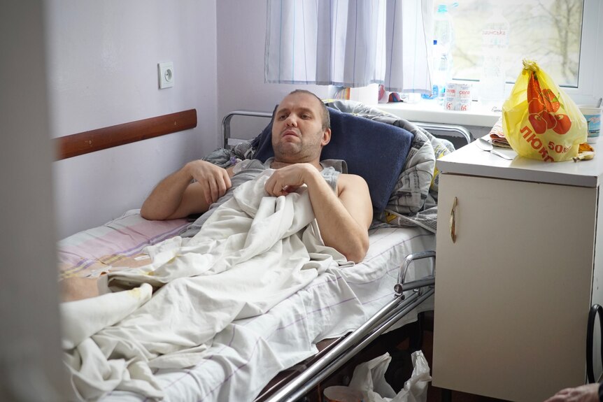 다리에 상처를 호소하는 병원에 누워있는 젊은 남자.