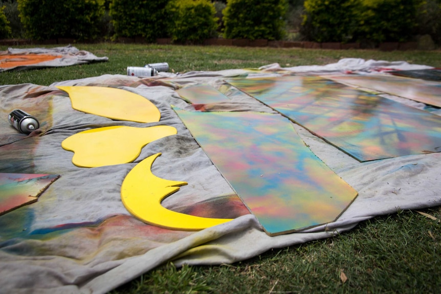 Coloured panels of wood lie on a sheet.