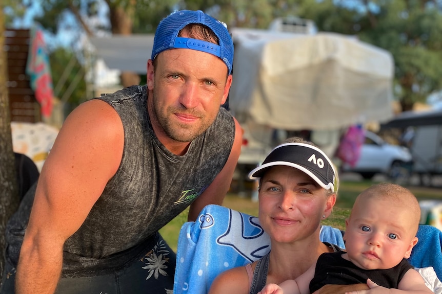 A man, woman and baby at a camping ground