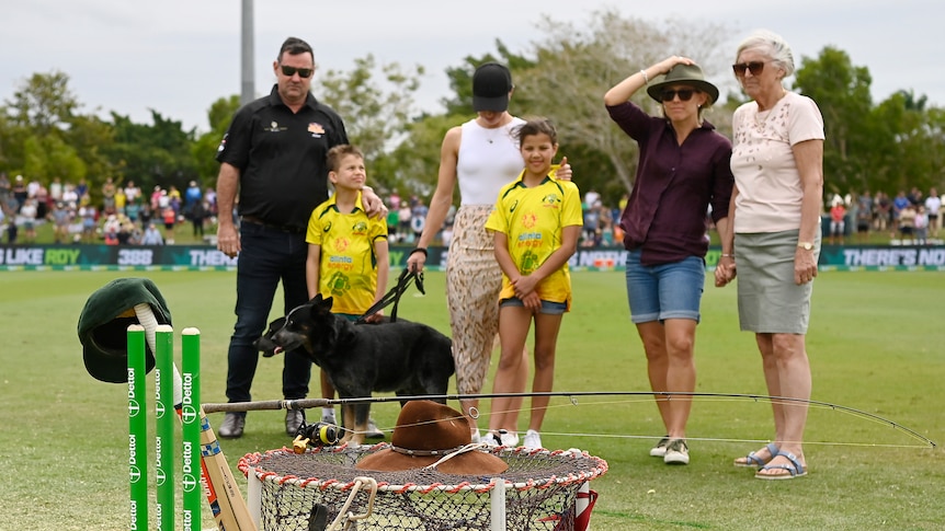 Andrew Symonds family stand around with crab pot and other personal items on pitch.