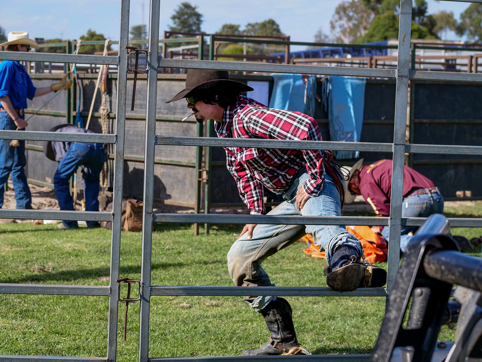 A man smoking a cigarette stretches.