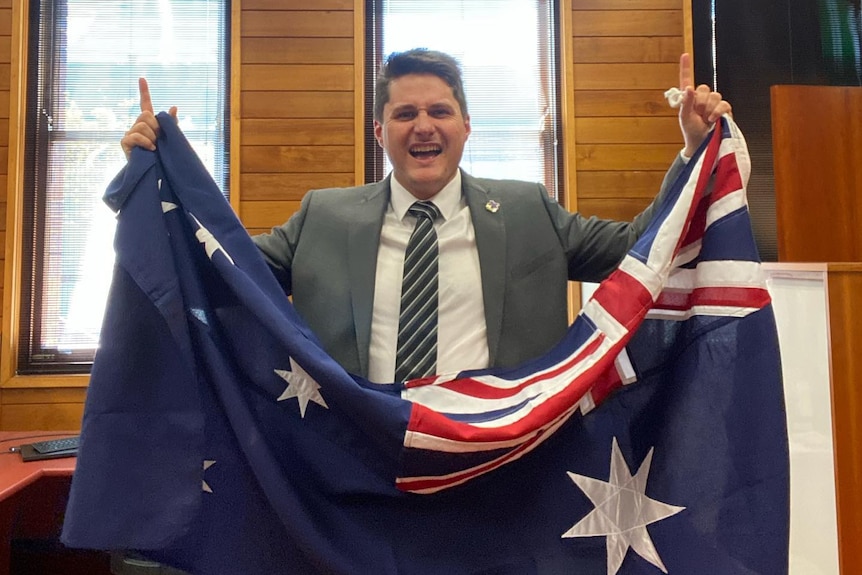 A man in a suit with the Australian flag. 