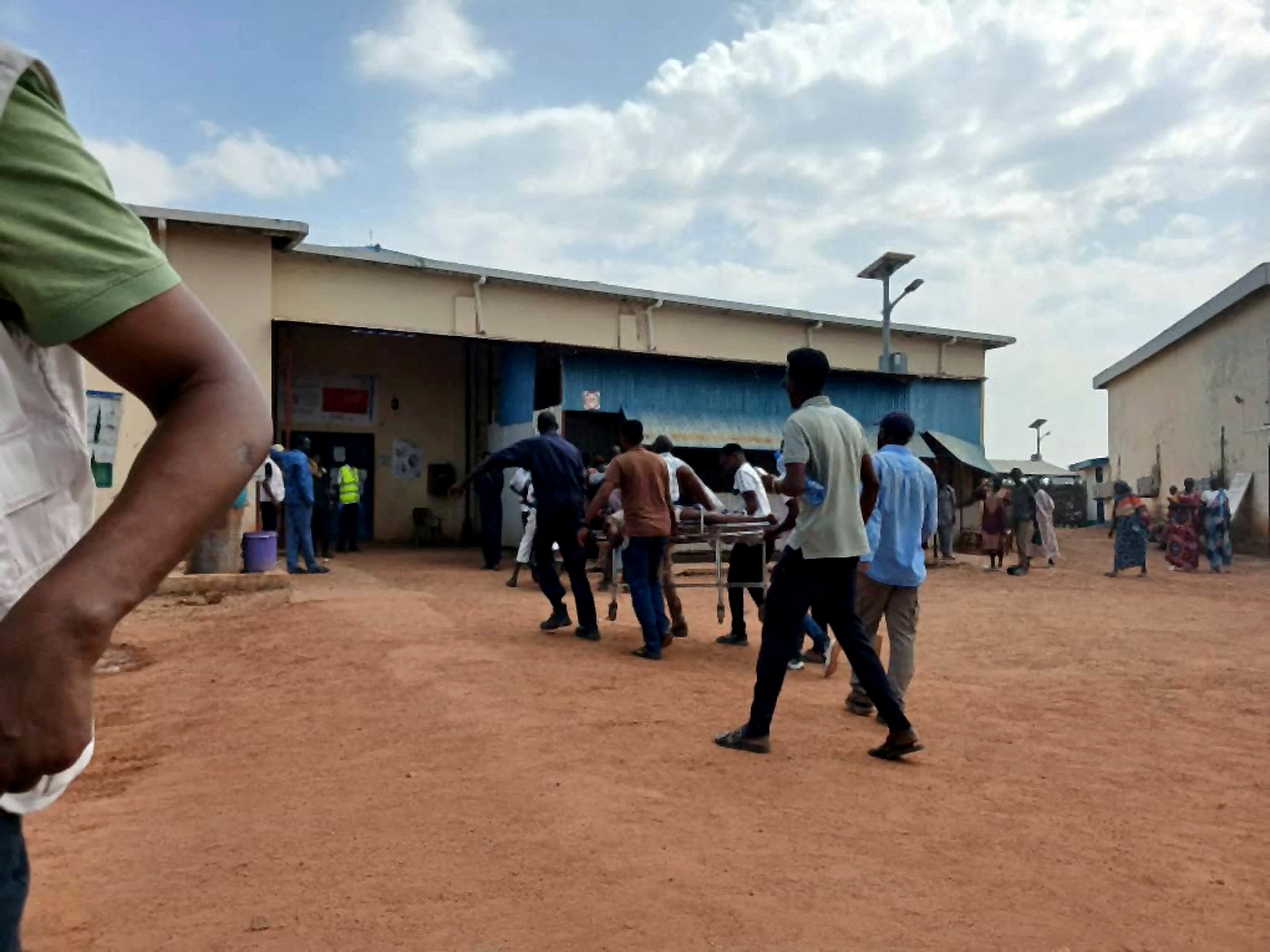 A wounded person is carried into hospital.