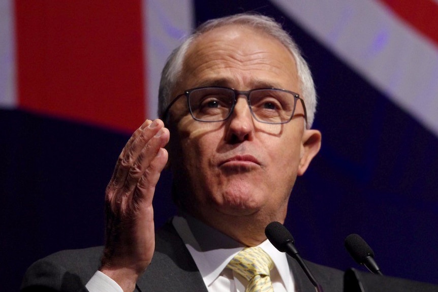 Headshot of Malcolm Turnbull with his hand raised in a gesture.
