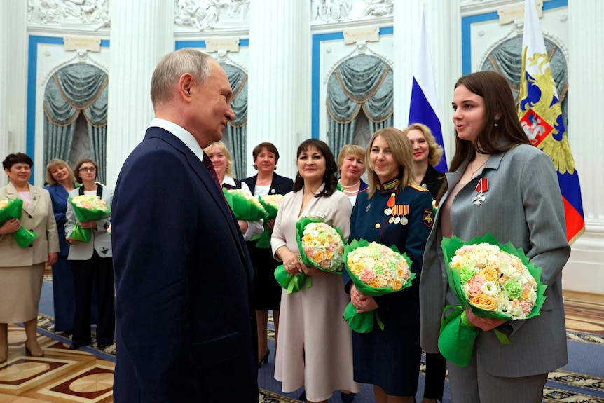 Russian President Vladimir Putin talks with participants of a ceremony to award outstanding Russian women.