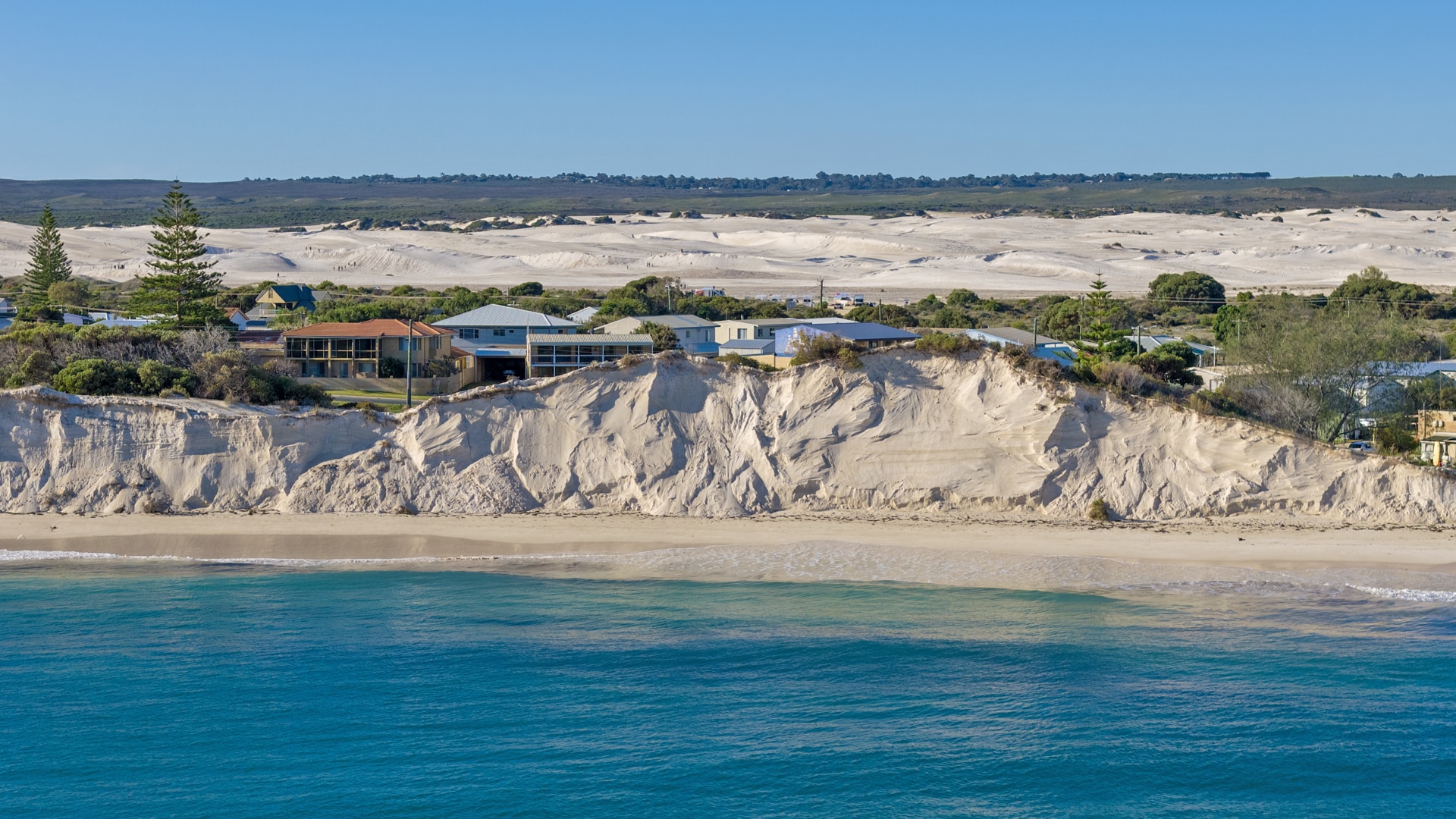 The ocean in front of a severley eroded dune.