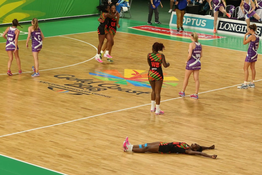 Takondwa Lwazi celebrates on the floor of the netball court.