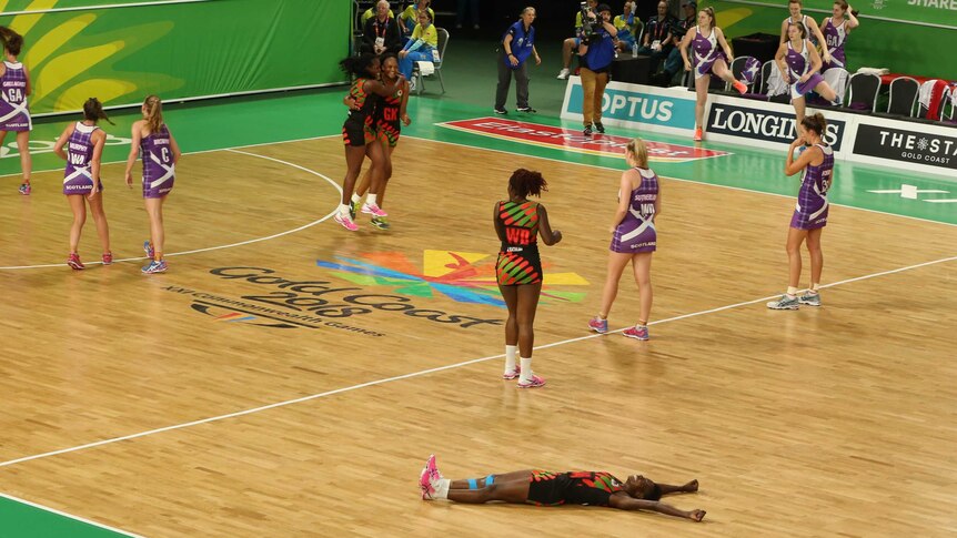 Takondwa Lwazi celebrates on the floor of the netball court.