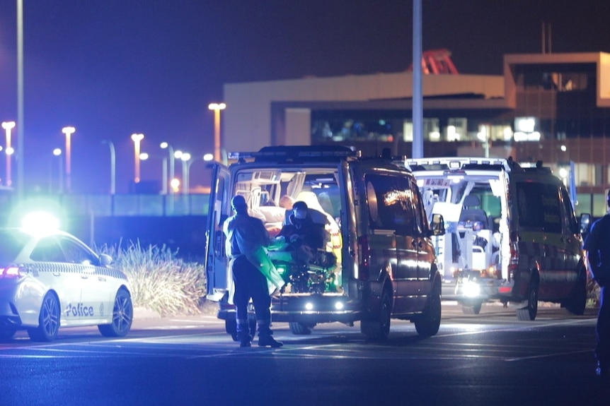 Ambulances lined up three in a row, a stretcher