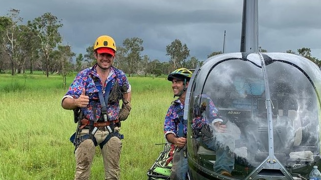 Chris Wilson stands next to a helicopter.