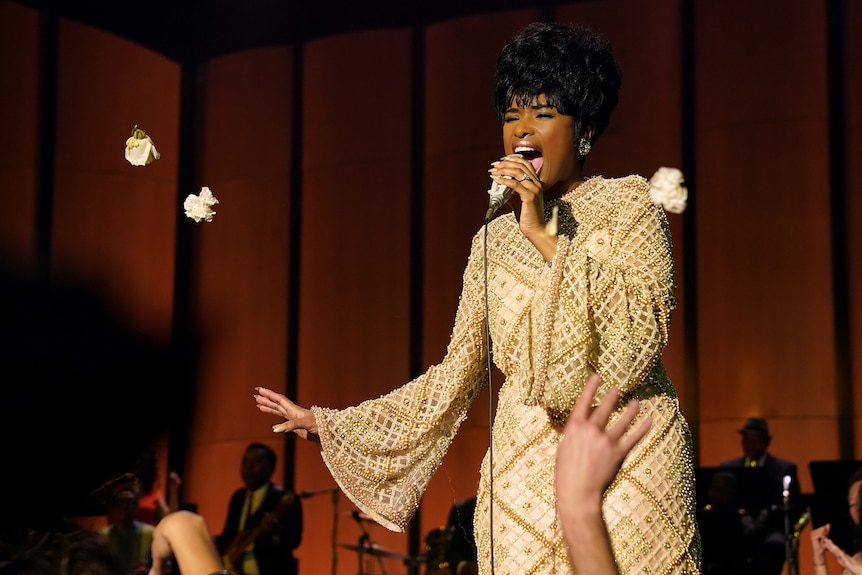Jennifer Hudson gives an impassioned stage performance, dressed lavishly in sequins which glimmer under a warm spotlight.
