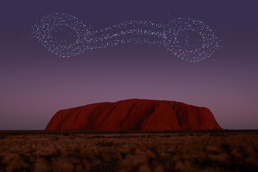Lights form a pattern in the night sky above Uluru.