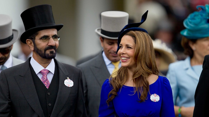 Sheikh Mohammed Al Maktoum and his wife Princess Haya walk towards the paddock dressed for the races.