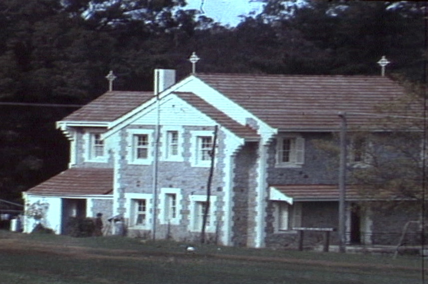 A grainy screenshot of a building with crosses on the roof in a rural location.