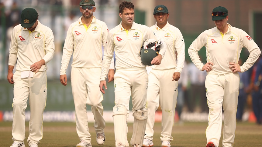 Five Australian male Test players walk off the field after losing to India in Delhi.