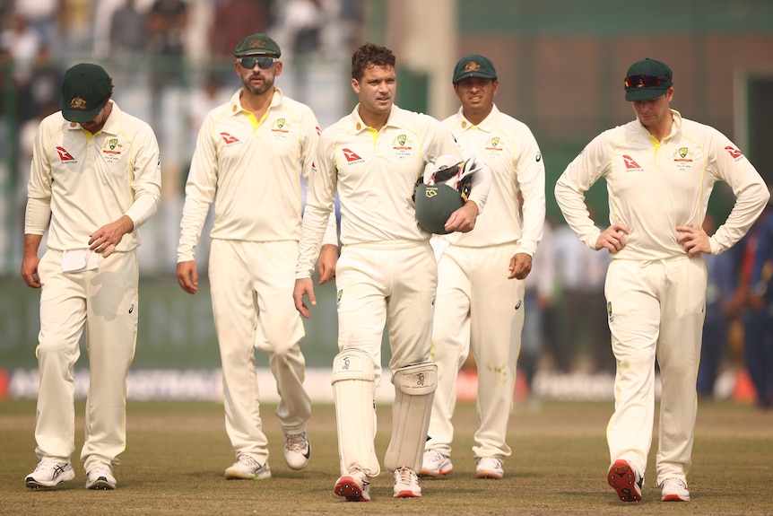 Five Australian male Test players walk off the field after losing to India in Delhi.